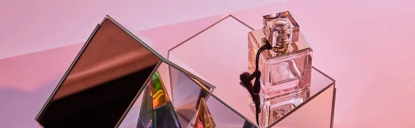 Crystal transparent pyramid near perfume bottle and mirror cubes on pink background, panoramic crop — Stock Photo