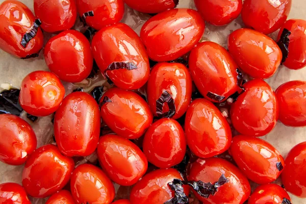 Vue du dessus des tomates avec feuilles de basilic coupées sur papier cuisson — Photo de stock