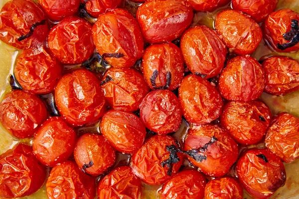 Vue du dessus des tomates cuites avec des feuilles de basilic coupées sur du papier cuisson — Photo de stock