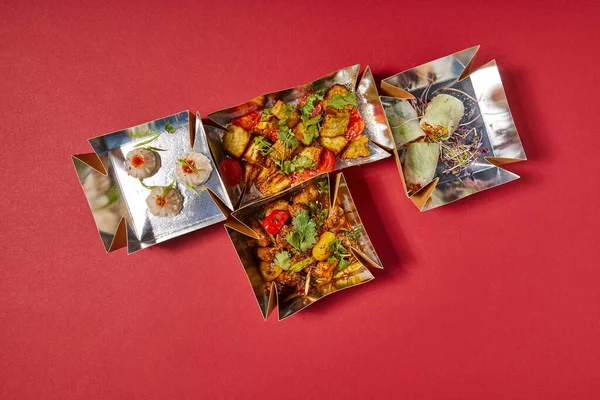Délicieux plats chinois dans des boîtes à emporter sur rouge — Photo de stock