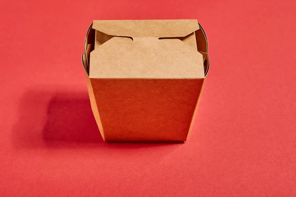 Top view of cardboard takeaway box with chinese food on red — Stock Photo