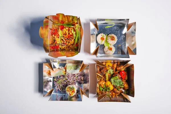 Top view of tasty and spicy chinese food in takeaway boxes on white — Stock Photo