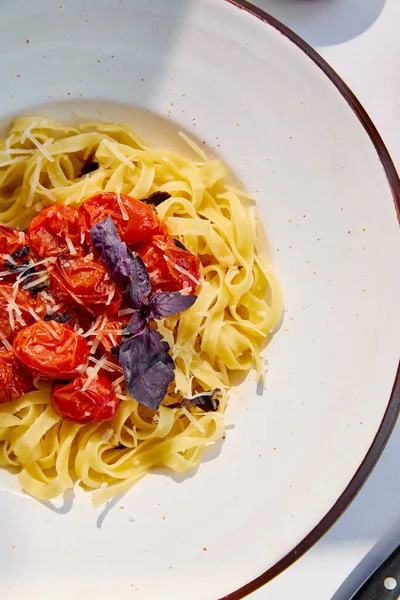 Top view of delicious pasta with tomatoes in round plate — Stock Photo
