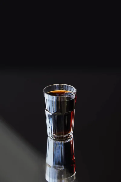 Soda frais en verre avec réflexion à la lumière du soleil sur fond noir — Photo de stock