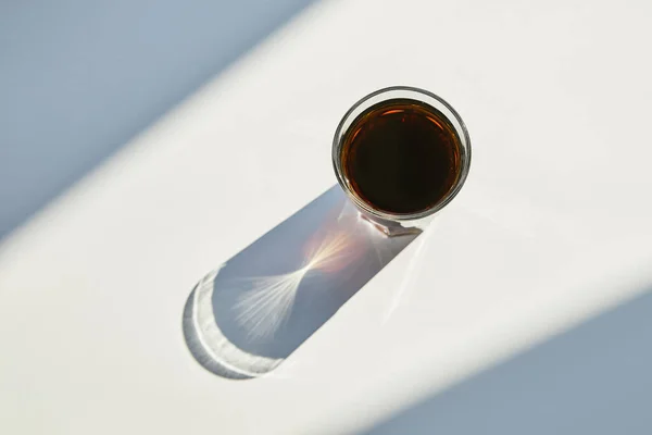 Top view of tasty soda in glass on white table in sunlight with shadow — Stock Photo