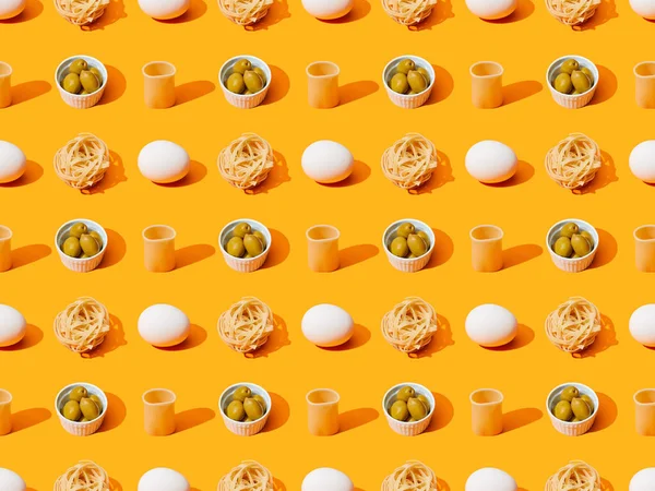 Fresh white chicken eggs, pasta and olives on orange colorful background, seamless pattern — Stock Photo