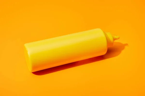 Bottle of mustard on orange colorful background — Stock Photo