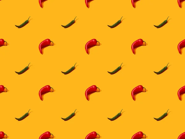 Red spicy chili peppers and jalapenos on orange colorful background, seamless pattern — Stock Photo