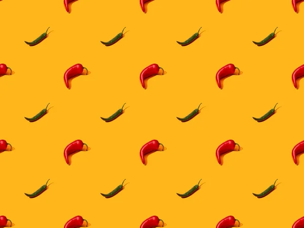 Chiles picantes rojos y jalapeños sobre fondo de color naranja, patrón sin costuras — Stock Photo