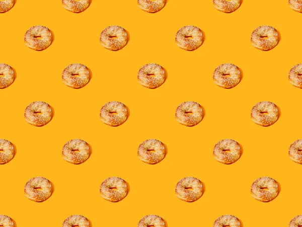 Frische Brötchen auf orangefarbenem Hintergrund, nahtloses Muster — Stockfoto