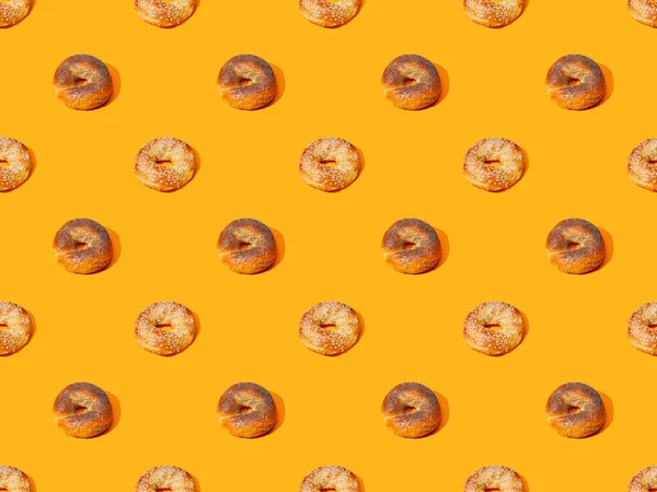 Frische Brötchen auf orangefarbenem Hintergrund, nahtloses Muster — Stockfoto