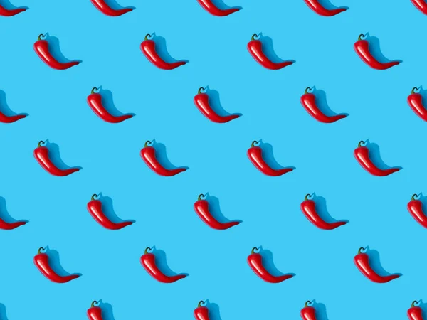 Top view of red spicy chili peppers on blue colorful background, seamless pattern — Stock Photo