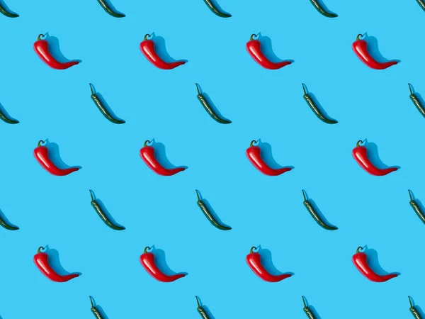 Top view of red spicy chili peppers and jalapenos on blue colorful background, seamless pattern — Stock Photo