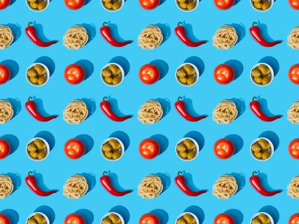 Top view of fresh pasta with olives, tomatoes and chili peppers on blue background, seamless pattern — Stock Photo