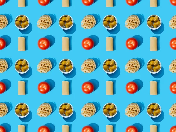 Vue du dessus des pâtes fraîches aux olives, tomates sur fond bleu, motif sans couture — Photo de stock