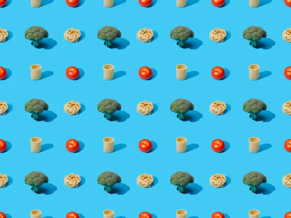 Fresh pasta with broccoli and tomatoes on blue background, seamless pattern — Stock Photo