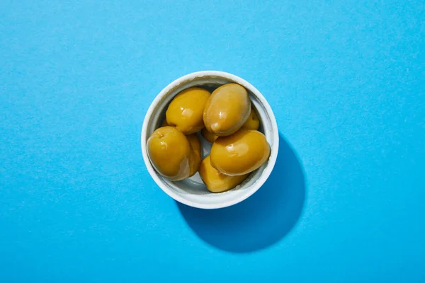 Top view of olives in bowl on blue colorful background — Stock Photo