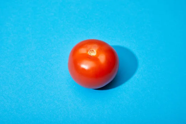 Ripe fresh tomato on blue background — Stock Photo