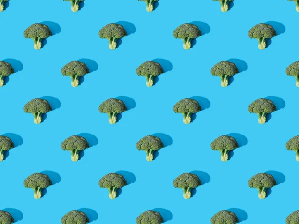 Top view of fresh green broccoli on blue background, seamless pattern — Stock Photo