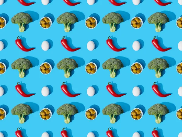 Top view of fresh green broccoli, eggs, chili peppers and olives on blue background, seamless pattern — Stock Photo