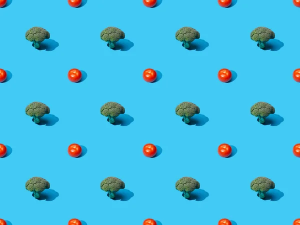 Fresh green broccoli and tomatoes on blue background, seamless pattern — Stock Photo