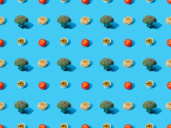 Fresh pasta with broccoli, olives and tomatoes on blue background, seamless pattern — Stock Photo