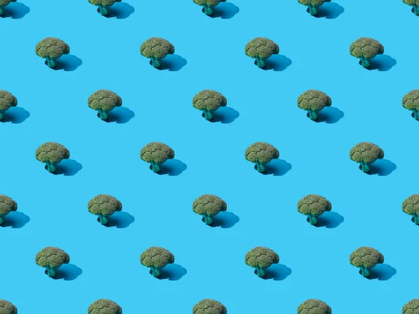 Fresh green broccoli on blue background, seamless pattern — Stock Photo