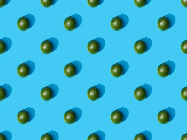 Vista superior de limas enteras frescas sobre fondo colorido azul, patrón sin costuras - foto de stock