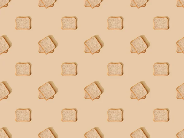 Vista superior del pan tostado fresco sobre fondo beige, patrón sin costuras - foto de stock