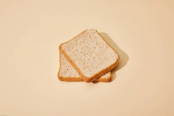 Ломтики хлеба на бежевом фоне — стоковое фото