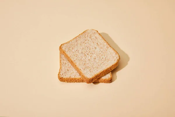 Frische Toastbrotscheiben auf beigem Hintergrund — Stockfoto