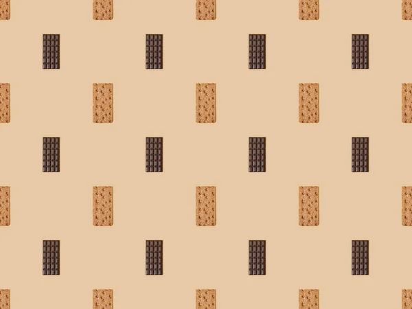 Top view of sweet dark chocolate bars and crispbread on beige background, seamless pattern — Stock Photo