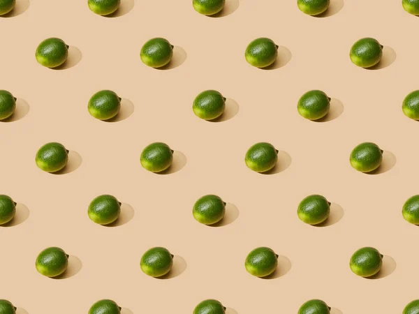 Fresh whole limes on beige background, seamless pattern — Stock Photo