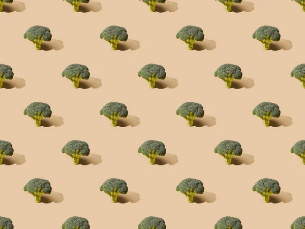 Fresh green broccoli on beige background, seamless pattern — Stock Photo