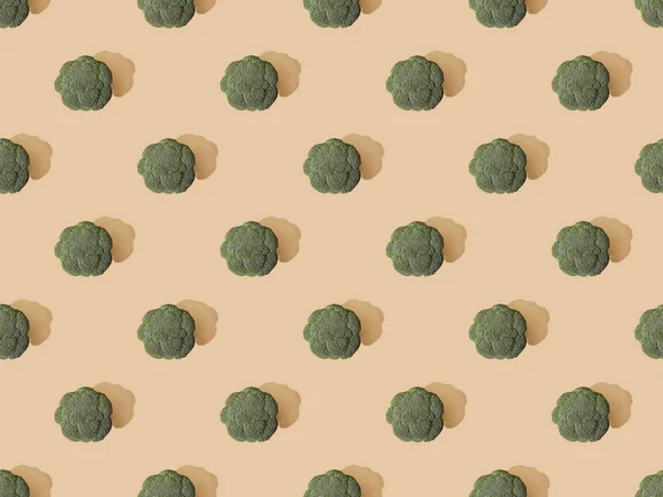 Top view of fresh green broccoli on beige background, seamless pattern — Stock Photo