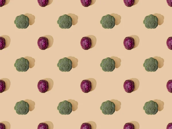 Top view of whole ripe red cabbage and broccoli on beige background, seamless pattern — Stock Photo