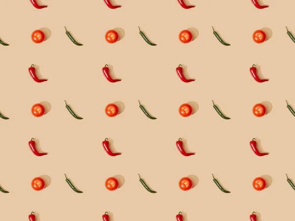 Top view of red spicy chili peppers and jalapenos with tomatoes on beige background, seamless pattern — Stock Photo