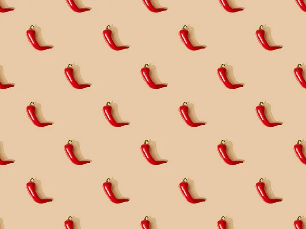 Vista superior de pimentas picantes vermelhas no fundo bege, padrão sem costura — Fotografia de Stock
