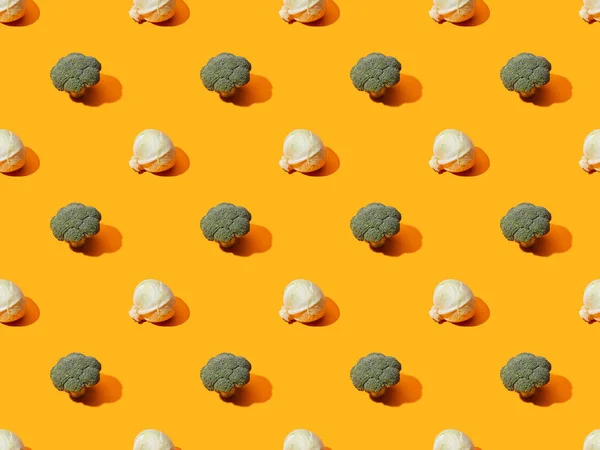 Frischer grüner Brokkoli und Kohl auf orangefarbenem Hintergrund, nahtloses Muster — Stockfoto