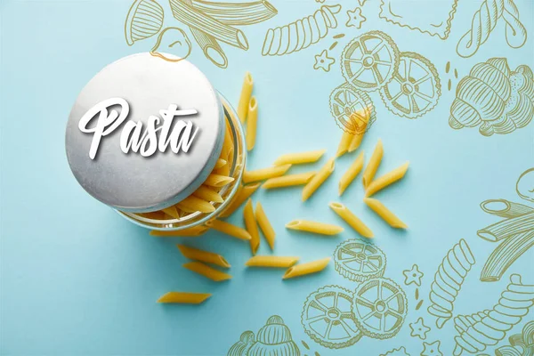 Top view of raw penne scattered from jar on blue background with pasta illustration — Stock Photo