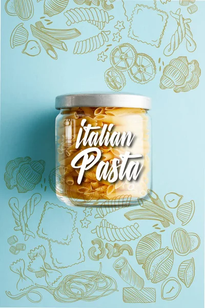 Vue du haut du penne cru en pot avec illustration de pâtes italiennes sur fond bleu — Photo de stock