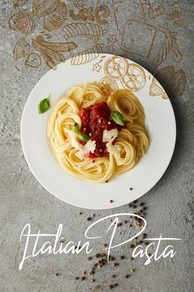 Top view of delicious spaghetti with tomato sauce on plate on grey textured surface with Italian pasta illustration — Stock Photo