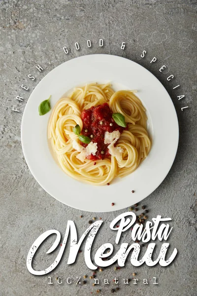 Вид сверху на вкусные спагетти с томатным соусом на серой текстурированной поверхности с иллюстрацией меню макарон — стоковое фото