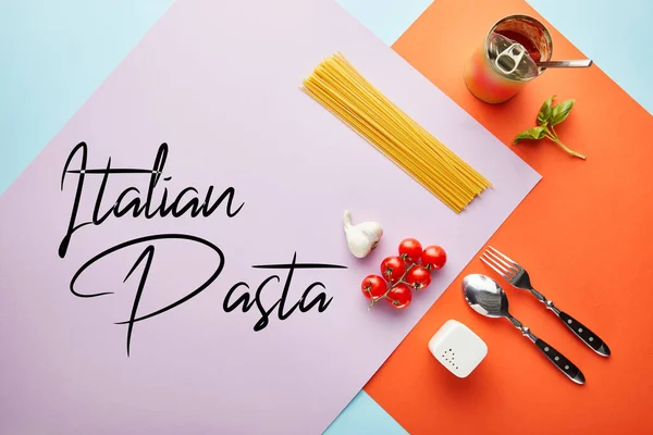 Flat lay with delicious spaghetti with tomato sauce ingredients on red, blue and violet background with Italian pasta illustration — Stock Photo
