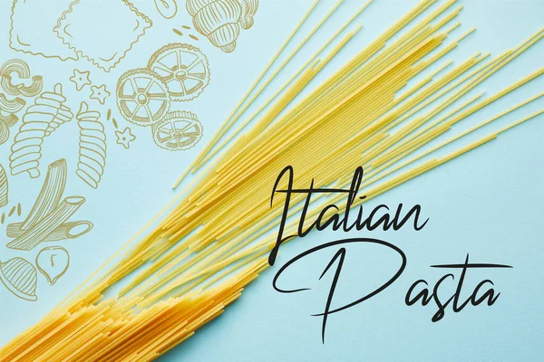 Зверху вигляд сирого спагетті на синьому тлі з ілюстрацією італійської макарони. — стокове фото
