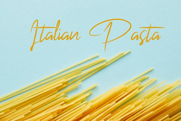 Vista dall'alto di spaghetti crudi su sfondo blu con illustrazione di pasta italiana — Foto stock