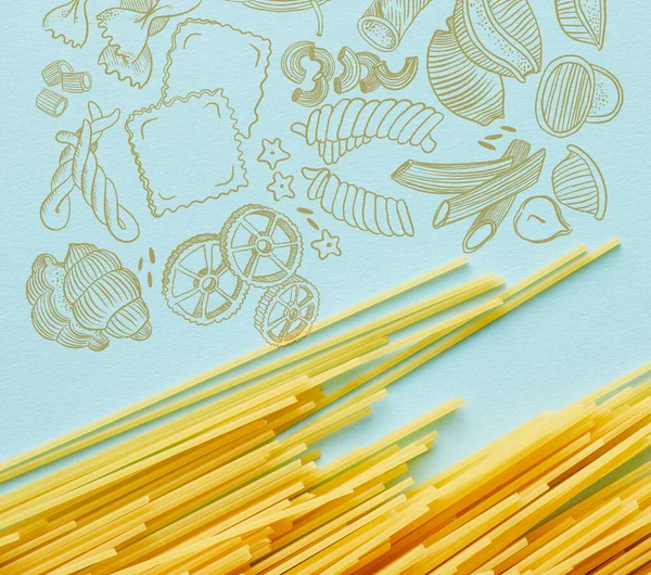 Top view of raw spaghetti on blue background with food illustration — Stock Photo