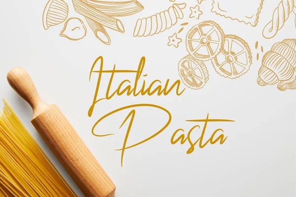 Vista superior de espaguetis y rodillo sobre fondo blanco, ilustración de pasta italiana - foto de stock