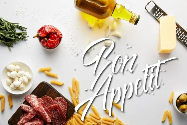 Vista superior de la botella de aceite de oliva, plato de carne, rallador, pasta e ingredientes en blanco, bon appetit ilustración - foto de stock