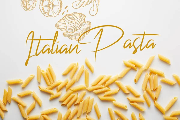 Top view of uncooked penne on white background, italian pasta illustration — Stock Photo